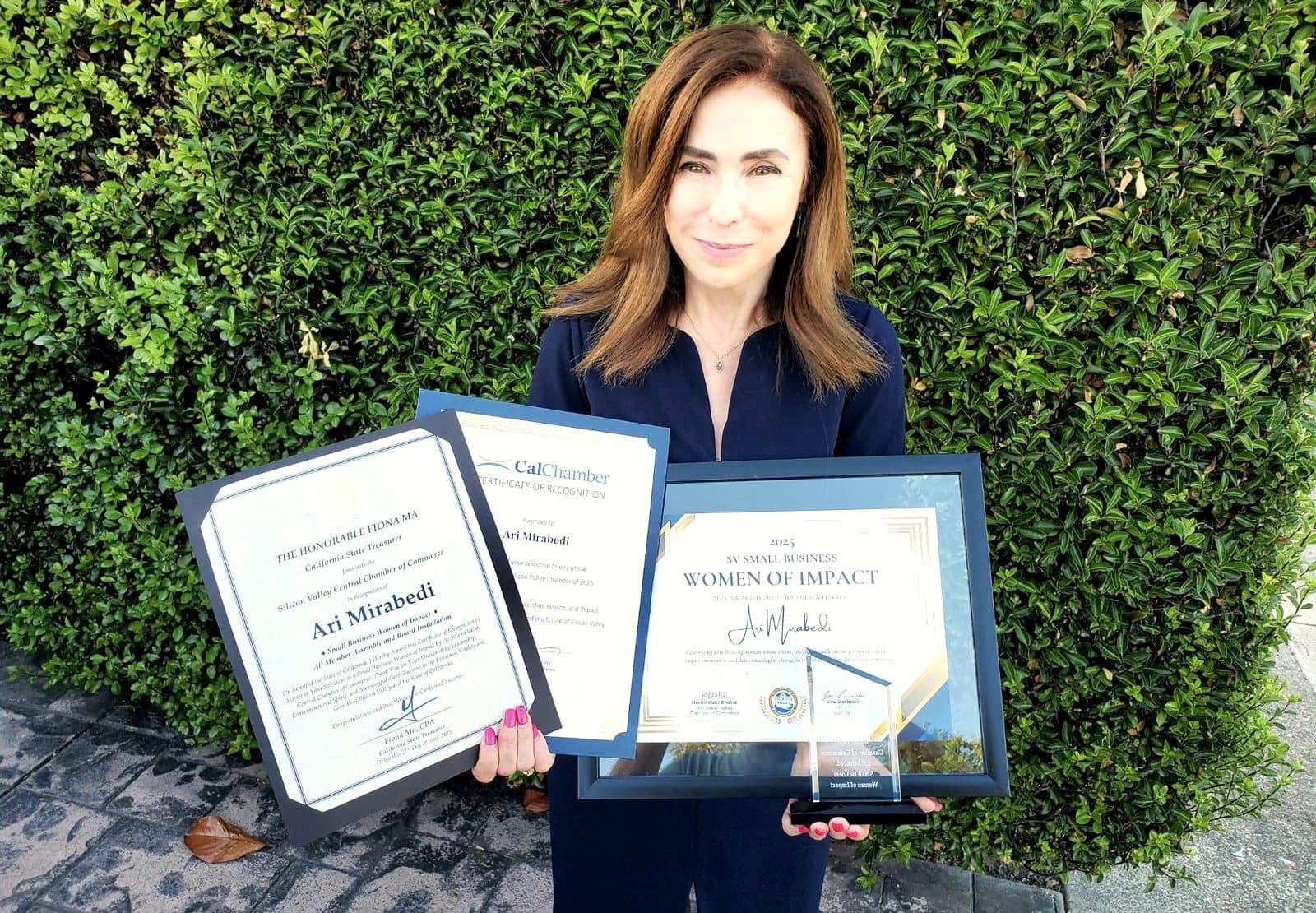 Ari Mirabedi holding her 2025 Silicon Valley Small Business Women of Impact award and two certificates of recognition